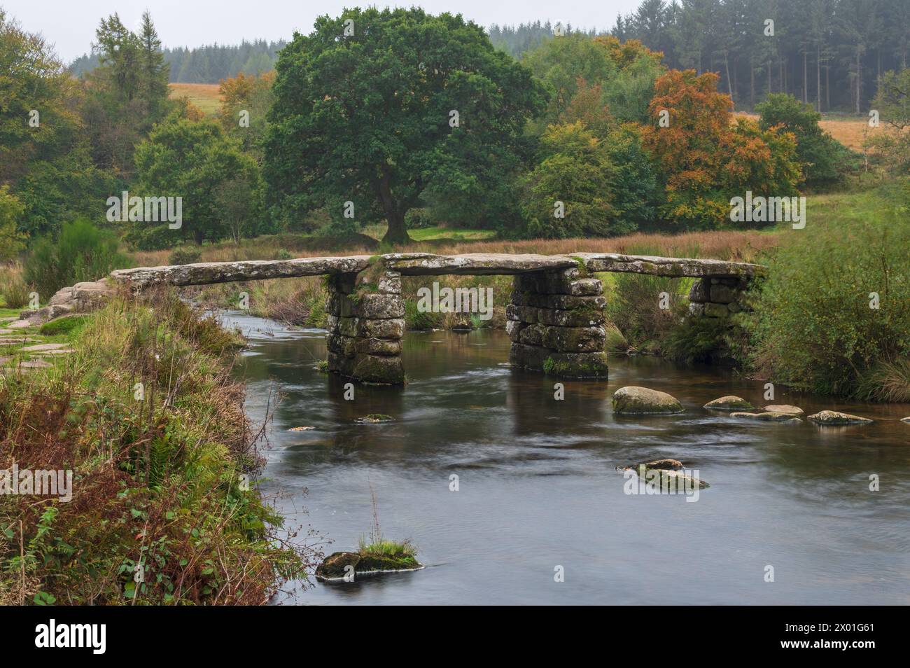 Die Steinklatschbrücke aus dem 13. Jahrhundert über den East Dart River im Dartmoor National Park bei Postbridge, Dartmoor, Devon, England Großbritannien Stockfoto