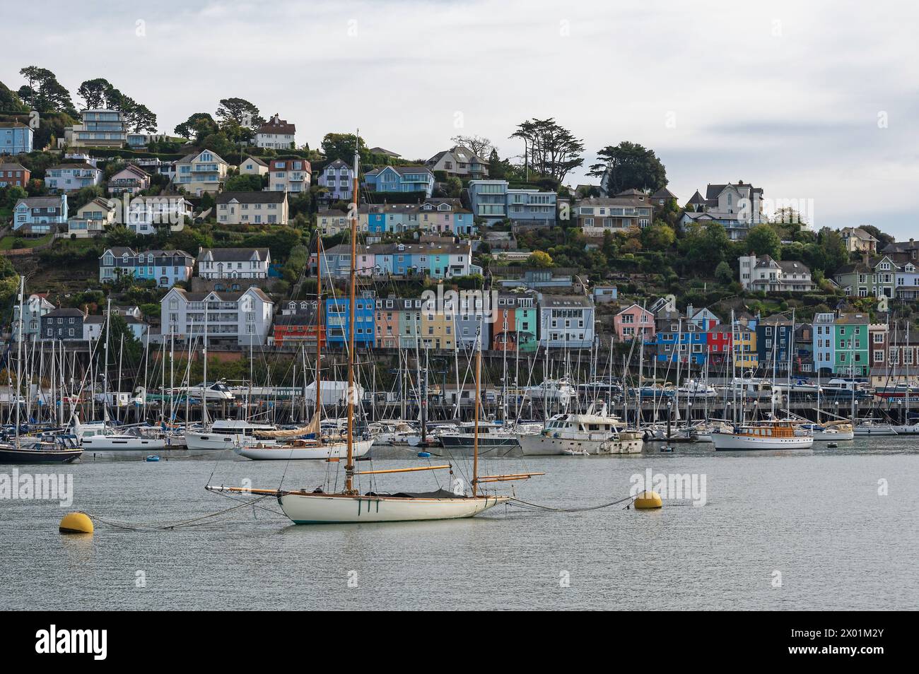 Boote liegen im Hafen von Dartmouth vor den farbenfrohen Häusern von Kingswear, Devon, England, Großbritannien, während einer Bootsfahrt vom Fluss Dart aus gesehen. Stockfoto