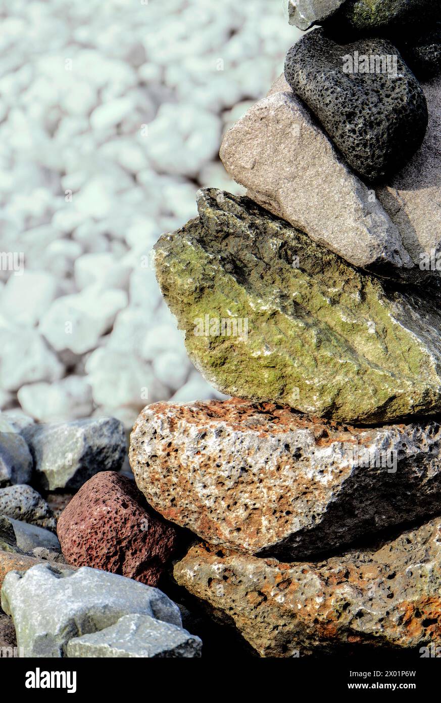 Ein Steinhaufen mit einem grünen Felsen in der Mitte. Die Felsen sind übereinander gestapelt Stockfoto