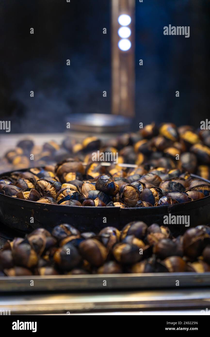 Nahaufnahme von gerösteten Kastanien draußen am Abend, Istanbul, Truthahn. Street Food. Vertikales Foto Stockfoto