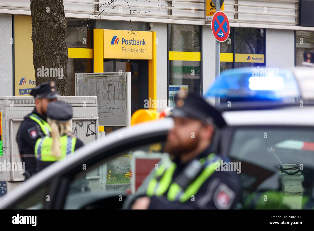 Hamburg, Deutschland. April 2024. Hamburger Polizeibeamte stehen während einer Operation vor einer Postbank-Filiale in Hamburg-Lurup. Am Dienstagmorgen wurde eine Postbank-Filiale im Hamburger Lurup-Center und den umliegenden Straßen abgesperrt und Sprengstoffentsorgungseinheiten gerufen. Quelle: Bodo Marks/dpa/Alamy Live News Stockfoto