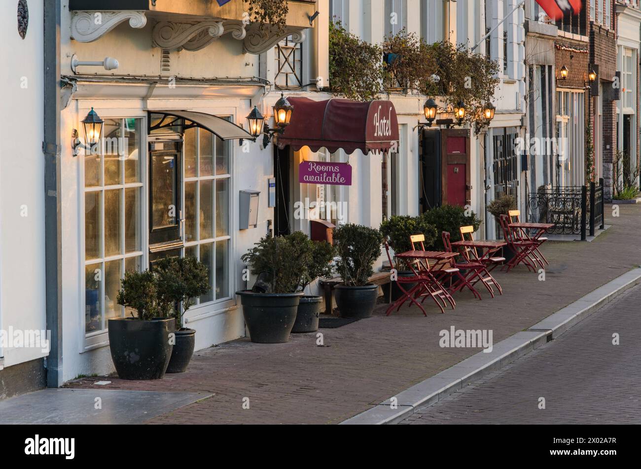Eingang zum Hotel und Tische entlang des Bürgersteigs. Stockfoto