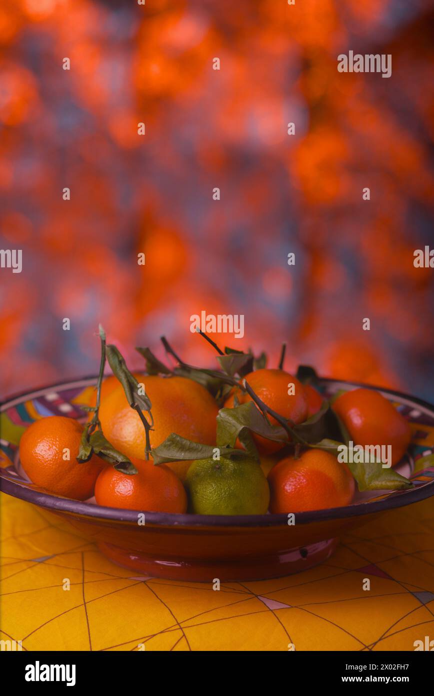 Warme Farbkomposition, Zitruskorb, Mandarinen und Orangen auf rotem Hintergrund Stockfoto