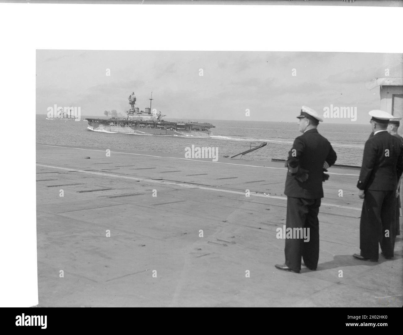 FORCE-H-OPERATIONEN IM MITTELMEER. 1942 AN BORD DES FLUGZEUGTRÄGERS HMS ARGUS. - Der Kapitän der HMS ARGUS, Captain G T Philips, DSO, RN, beobachtet HMS EAGLE und HMS MALAYA vom Flugdeck Royal Navy, EAGLE (HMS), Flugzeugträger (1918) Stockfoto