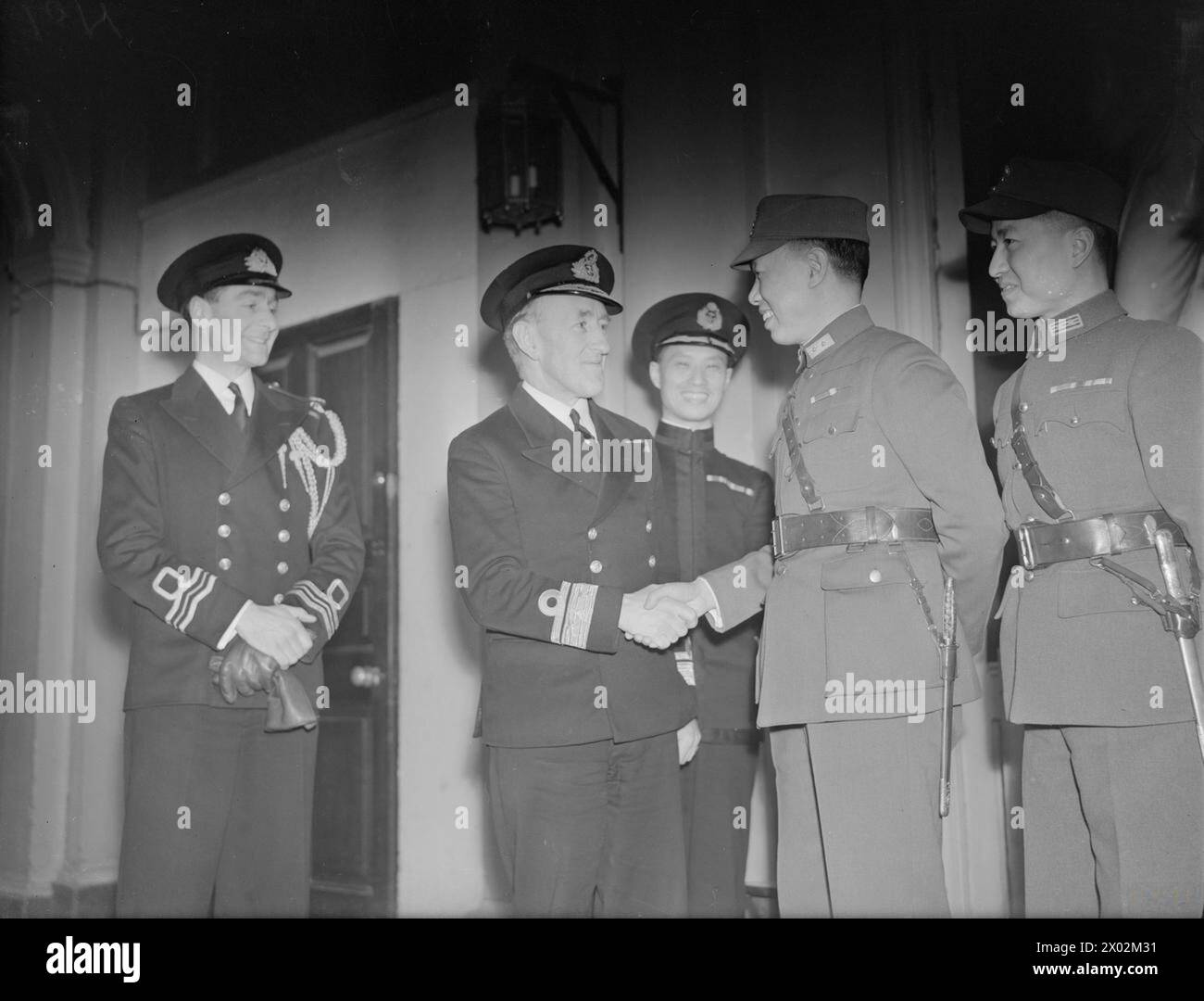 CHINESISCHER GENERAL BESUCHT DIE ADMIRALITÄT. AM 23. FEBRUAR 1943 BESUCHT DIE ADMIRALITÄT, GENERAL HSIUNG SHIH-HUI, SEIT SOMMER 1942 LEITER DER CHINESISCHEN MILITÄRMISSION IN WASHINGTON, DAS VEREINIGTE KÖNIGREICH KURZ, BEVOR SIE WIEDER ZU CHUNKING ZURÜCKKEHRT. BEI IHM SIND 2 MITGLIEDER DES MISSIONSTABS, DR HO FUNG-SHAN UND CAPTAIN LI MING-HSIEA. - Konteradmiral R R McGrigor begrüßt Generalleutnant Hsiung Shih-hui bei seiner Ankunft in der Admiralität. Mit ihnen (Mitte) ist Kommandeur Chow Ying-tsung (chinesischer Marineattaché) Stockfoto