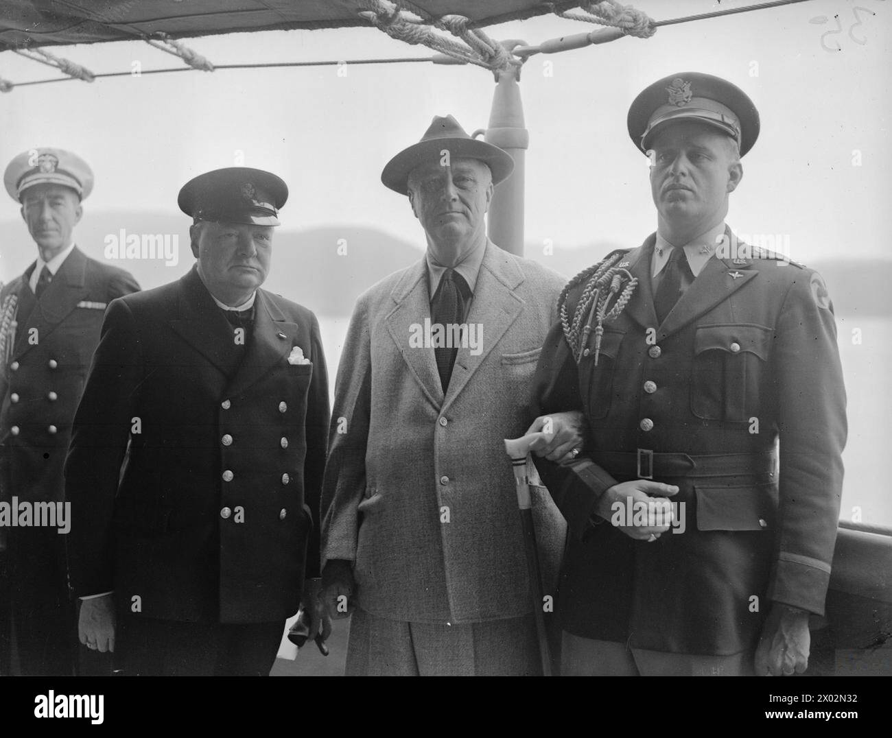 Am 10. August 1941 trafen sich Premierminister Winston Churchill und Präsident Franklin D. Roosevelt während der Atlantic Conference an Bord der HMS Prince of Wales, wobei Captain Elliot Roosevelt und ein Berater des Präsidenten anwesend waren. Stockfoto