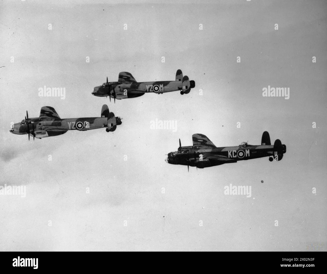 Offizielles Foto: Avro Lancaster B Mark 1 (Specials), PD118 „YZ-M“, PD129 „YZ-O“ und A B Mark 1, NG489 „KC-M“, alle aus No. 617 Squadron, Royal Air Force, mit Sitz im Woodhall Spa, fliegend in „vic“-Formation, 8. Mai 1945. (Frontansichten mit drei Seitenansichten) Stockfoto