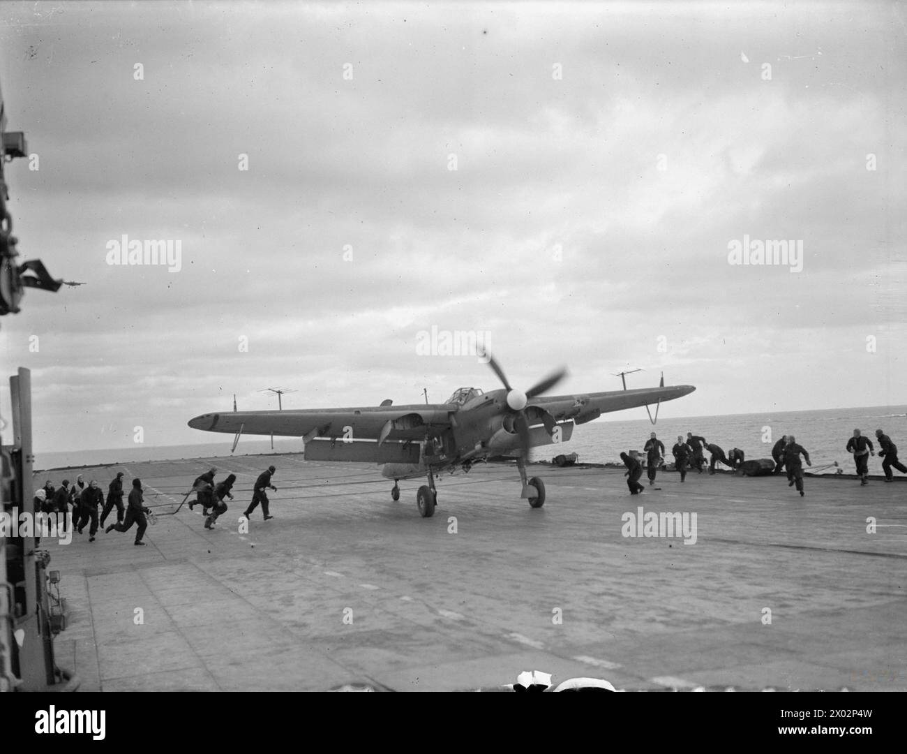 Am 3. April 1944 räumten Mitarbeiter der Flotte Air Arm an Bord der HMS Furious im norwegischen Altenfjord eine Fairey Barracuda ab, nachdem sie das deutsche Schlachtschiff Tirpitz angegriffen hatten. Stockfoto
