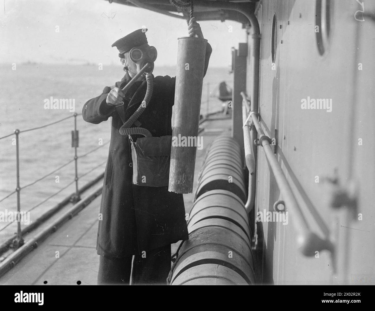 Im Februar 1941 führte die HMS Kelvin eine Gasbohrung im Plymouth Sound durch. Die Seeleute führten alle Aufgaben mit Gasmasken aus, wobei der Alarm mit einem leeren Hüttenkoffer ertönte. Stockfoto