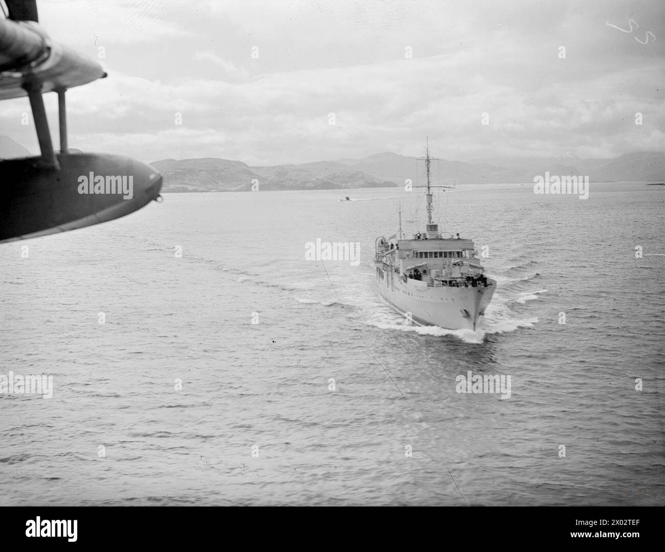 U-BOOTE ERGEBEN SICH AM LOCH ERIBOLL. 9. UND 10. MAI 1945, LOCH ERIBOLL, SCHOTTLAND. DIE ERSTE DEUTSCHE U-BOOT-FLOTTE BEGANN IHRE KAPITULATION VOR DEN TRUPPEN DER ROYAL NAVY. - HMS PHILANTE, ein Escort-Gruppe-Trainingsschiff, das zwei der übergebenen U-Boote nach Loch Eriboll führt, von einem Marineflugzeug HMS Philante aus gesehen Stockfoto