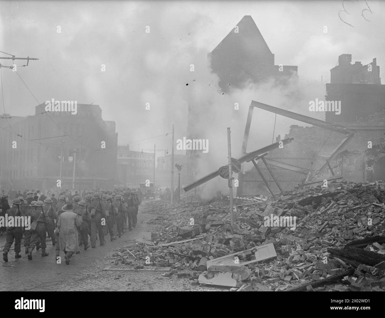 Soldaten marschieren am 16. November 1940 an bombenbeschädigten Gebäuden am Broadgate, Coventry, vorbei, nachdem deutsche Luftangriffe einen Großteil der Stadt zerstört hatten. Stockfoto