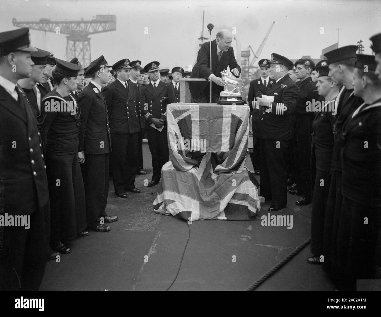 Im Oktober 1944 präsentierte Mr. D. J. Davis, Handelskommissar von Neufundland, dem Kreuzer HMS Newfoundland ein silbernes Modell des nationalen Emblems Caribou, das von Captain R. W. Ravenhill auf dem Quarterdeck akzeptiert wurde. Stockfoto