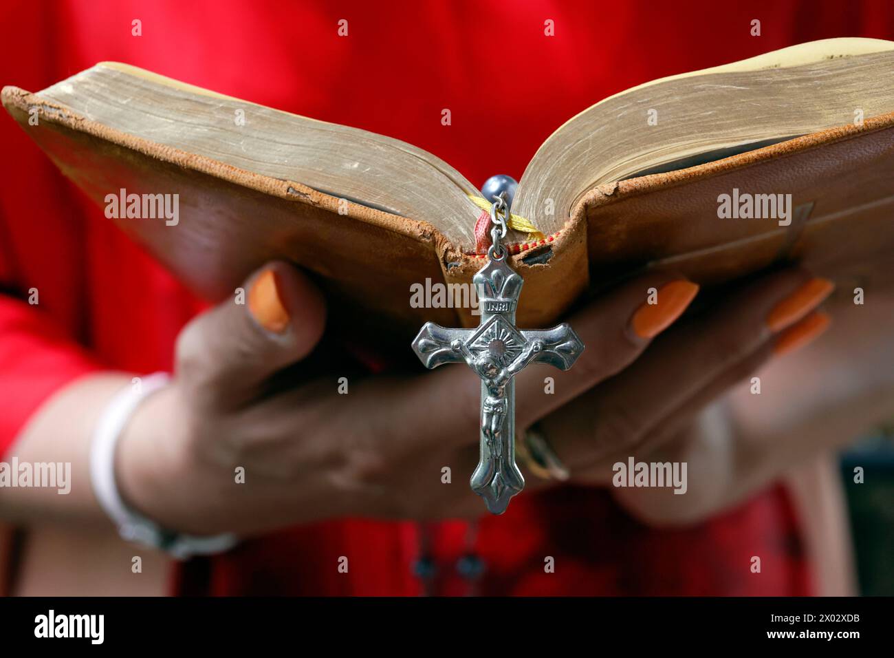 Frau, die die Heilige Bibel liest und Rosenkranz mit Jesus am Kreuz, Kambodscha, Indochina, Südostasien, Asien Stockfoto