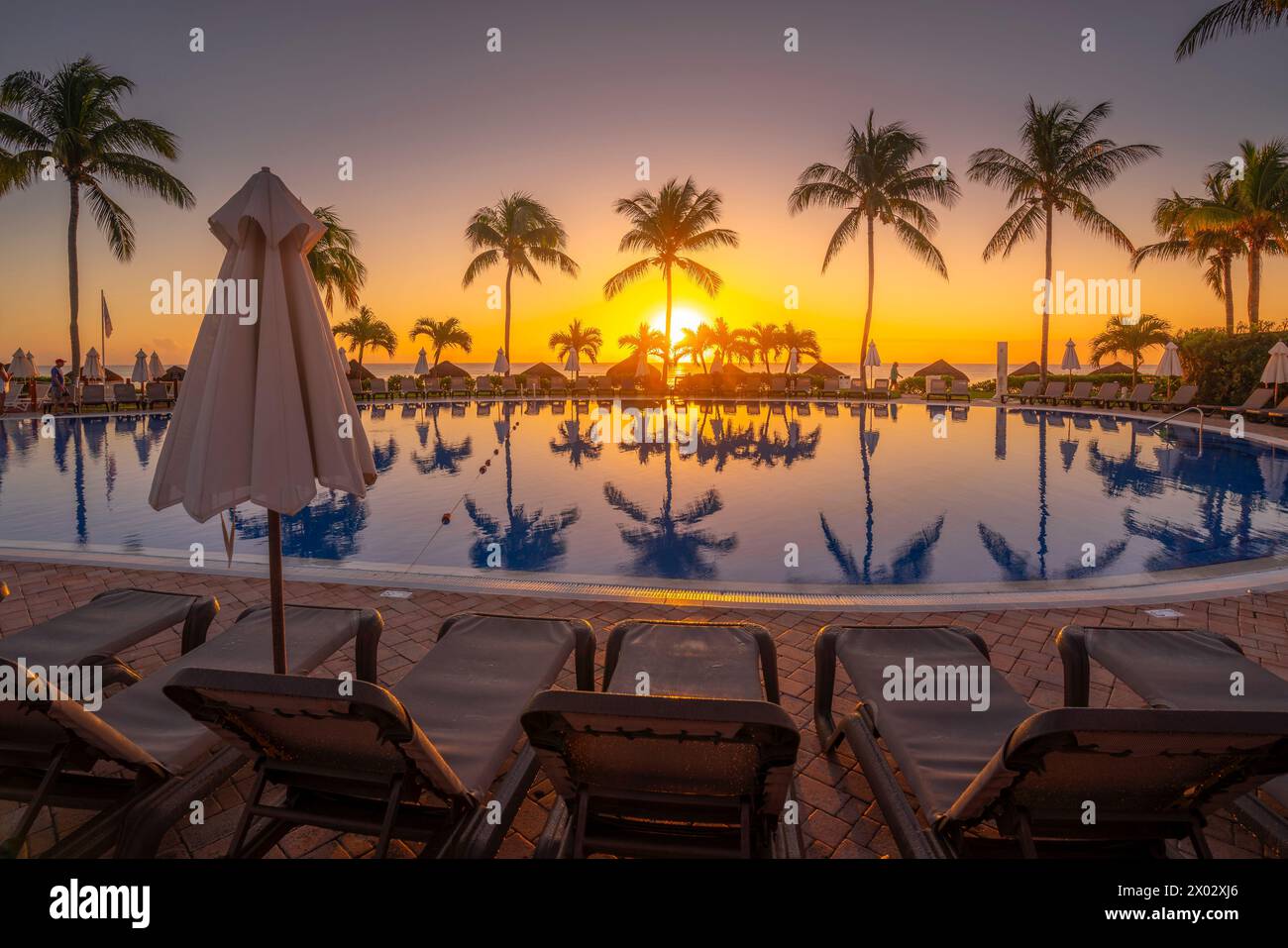 Blick auf Sonnenaufgang und Palmenspiegelungen im Hotelpool in der Nähe von Puerto Morelos, Karibikküste, Yucatan Halbinsel, Mexiko, Nordamerika Stockfoto