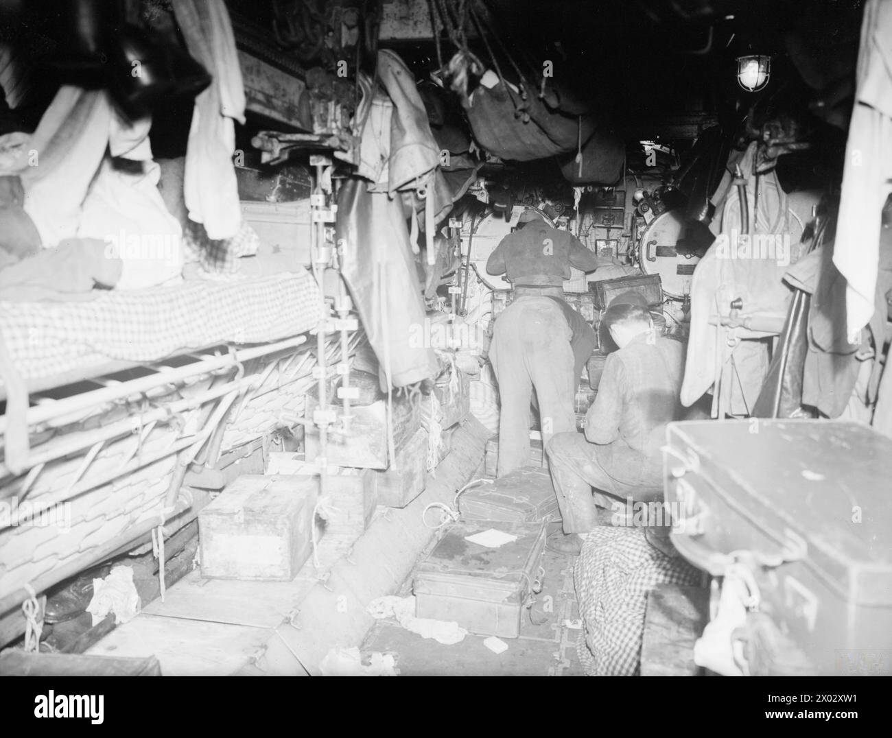 AN BORD DER KAPITULIERTEN U 532. 18. MAI 1945, GLADSTONE DOCK, LIVERPOOL. AN BORD DER U 532 GAB SICH DIE BLOCKADE DES DEUTSCHEN U-BOOTS AUF DEM WEG VON JAPAN MIT EINER LADUNG AUS TIN, CHININ, WOLFRAM UND GUMMI IM ATLANTIK AUF. - Die Torpedorohre und das Seemannschaos von U 532 Stockfoto