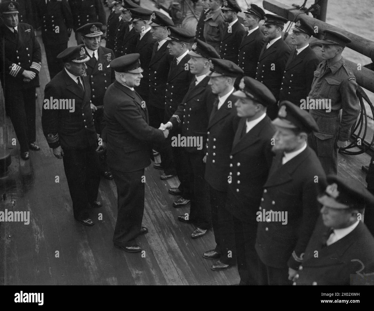 DER ERSTE HERR DER ADMIRALITÄT BESUCHT U-BOOT-DEPOT-SCHIFF. 6. JULI 1942. - Der erste Lord inspiziert Spezialpersonal an Bord eines Depotschiffs Stockfoto