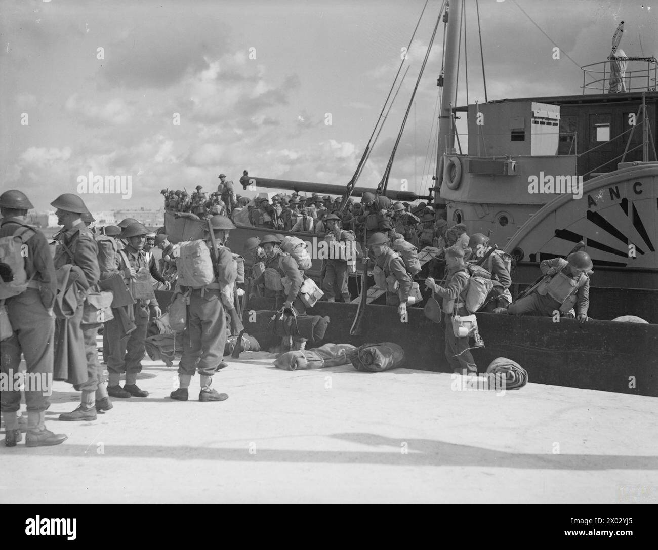 Am 27. Januar 1942 erreichte das von Kriegsschiffen eskortierte Versorgungsschiff SS Breconshire Grand Harbour, Malta, wo es Vorräte und Truppen lieferte, wobei britische Truppen von Schleppern und Feuerzeugen ausstiegen. Stockfoto