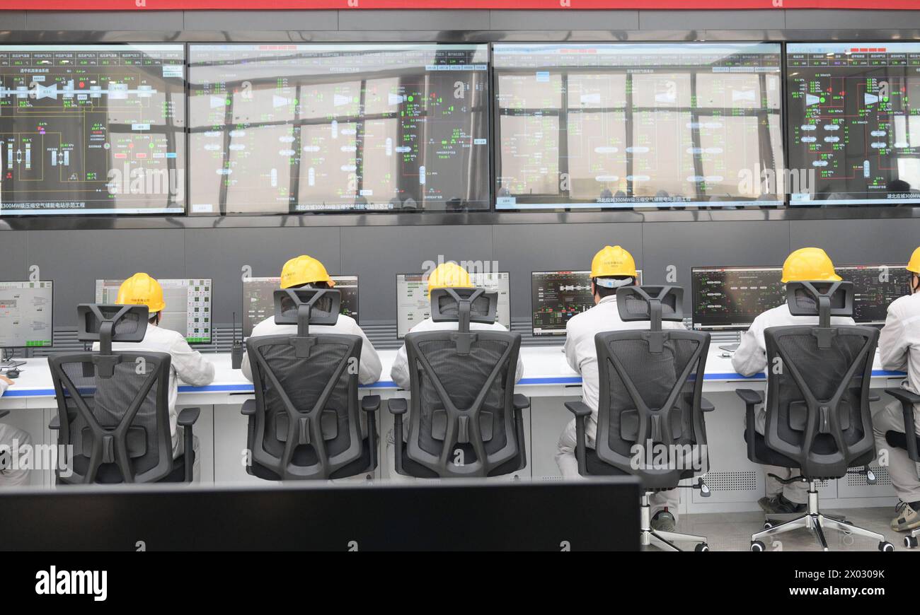 (240409) – WUHAN, 9. April 2024 (Xinhua) – Mitarbeiter arbeiten am 300 MW-Druckluftspeicher in Yingcheng, Zentralchinas Provinz Hubei, 9. April 2024. Der 300 MW-Druckluftspeicher in Yingcheng nahm am Dienstag den Betrieb auf. Mit der Technologie, die als „Druckluftenergiespeicher“ bezeichnet wird, würde Luft in die unterirdische Höhle gepumpt, wenn der Strombedarf gering ist, während die Druckluft in Zeiten erhöhter Nachfrage zur Stromerzeugung freigesetzt würde. Die als „Super Power Bank“ bezeichnete Station soll jährlich 500 Millionen kWh Strom erzeugen Stockfoto