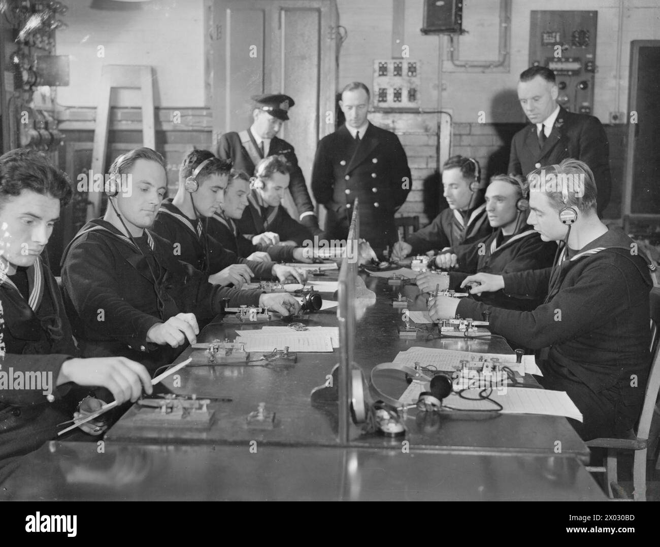 Polnische Marineschiffe erhalten 1941 Unterricht in einem drahtlosen Telegrafenraum, während Signalschulen der Royal Navy schnell Signalgeber für die alliierte Zusammenarbeit ausbilden. Stockfoto