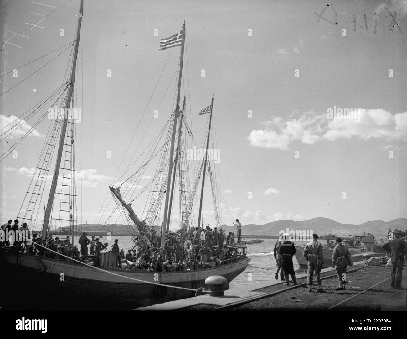 Am 15. Oktober 1944 landen Schiffe der britischen und der Royal Hellenic Navy im Hafen von Piräus in Athen an, um die Befreiung Griechenlands zu unterstützen. Ein griechischer Caique hilft dabei, britische Truppen an Land zu landen. Stockfoto Am 15. Oktober 1944 landen Schiffe der britischen und der Royal Hellenic Navy im Hafen von Piräus in Athen an, um die Befreiung Griechenlands zu unterstützen. Ein griechischer Caique hilft dabei, britische Truppen an Land zu landen. Stockfoto