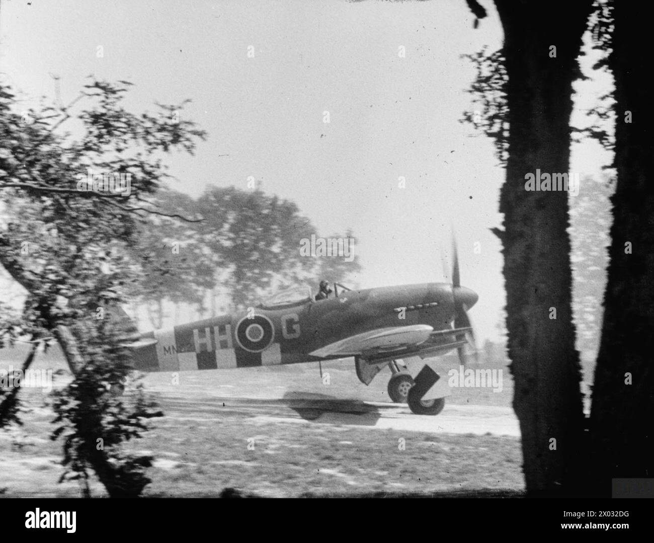 ROYAL AIR FORCE 1939-1945: JAGDKOMMANDO - mit leeren Raketenschienen fährt ein No. 175 Taifun zwischen den Bäumen bei Le Fresne-Camilly (B-5), nachdem er am 1. August 1944 aus einer Nahunterstützung zurückgekehrt ist. Bis zu diesem Zeitpunkt war die Kommunikation mit den Bodenkräften verbessert worden, und stehende Patrouillen von Taifunen („Führerstände“) konnten bei Bedarf von Vorwärtssteuern abgeholt werden, die mobile „visuelle Kontrollposten“ in der Frontlinie der Royal Air Force, Royal Air Force Regiment, Sqdn, 175, durchbohren Stockfoto