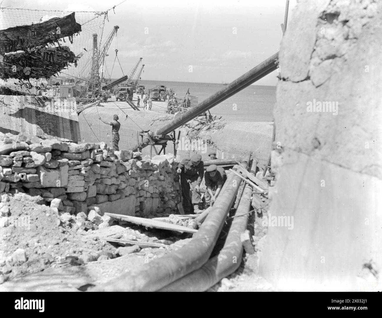 Zwischen dem 25. Und 29. Juni 1944 nahm Mulberry B den Betrieb als künstlicher Hafen in Arromanches auf, wobei Port-en-Bessin als POL-Hafen diente. Rohrleitungen wurden bei Port-en-Bessin an Land gelegt. Stockfoto