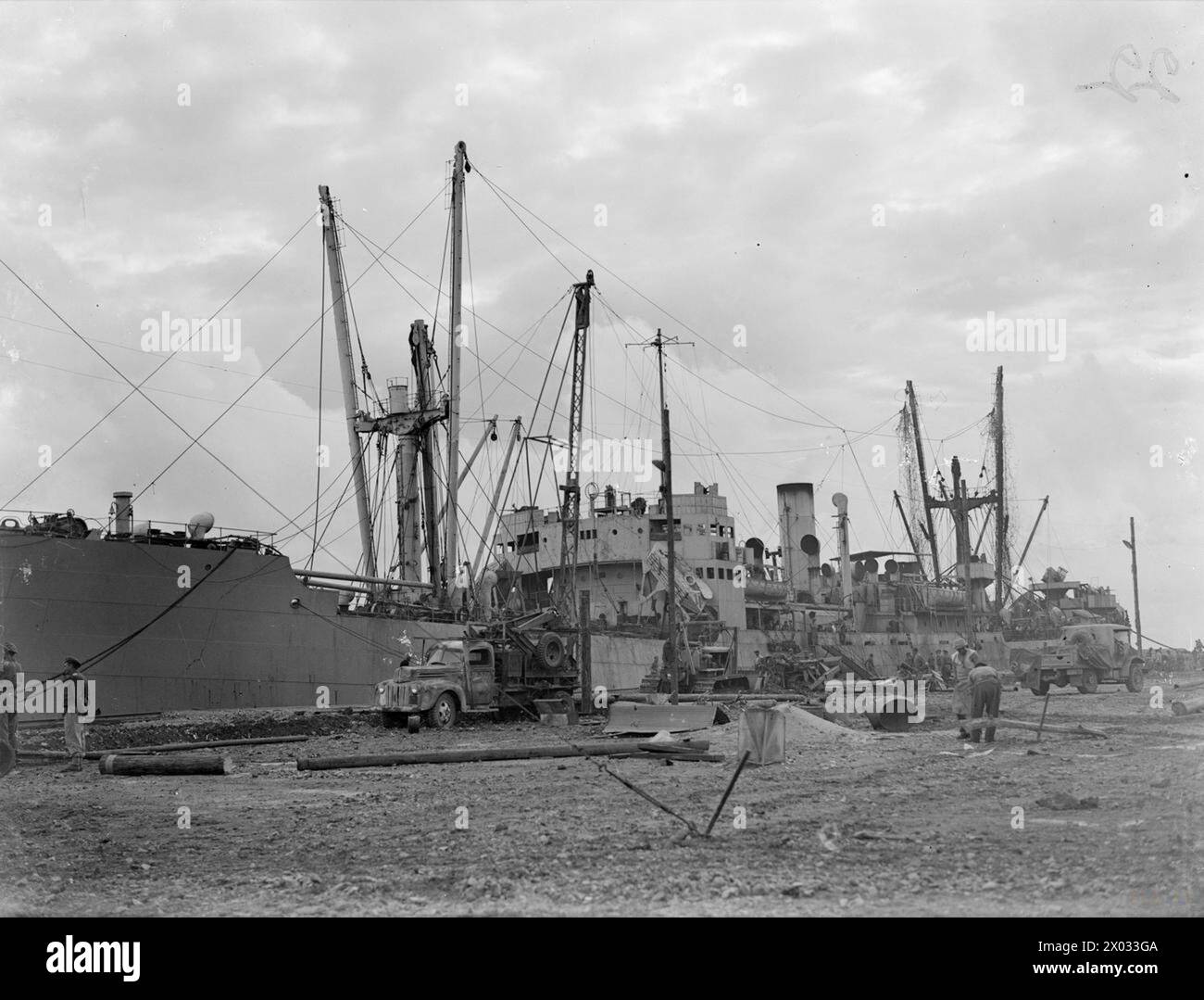 DIE BRITISCHE MARINE BRINGT LEBENSMITTEL NACH GRIECHENLAND. 20. UND 21. OKTOBER 1944, HAFEN VON PIRÄUS, ATHEN. BRITISCHE KAUFLEUTE, DIE VON SCHIFFEN DER BRITISCHEN UND GRIECHISCHEN MARINE BEGLEITET WURDEN, BRACHTEN DIE ERSTEN NAHRUNGSMITTELLIEFERUNGEN FÜR DIE HILFE GRIECHENLANDS. - Das erste Handelsschiff (SS COULGORN), das Piräus erreichte, mit 7000 Tonnen Mehl, Fleischkonserven und Käse entlang der Kai, wo britische Sapper und griechische Hafenarbeiter die Wiederaufbauarbeiten durchführen Stockfoto