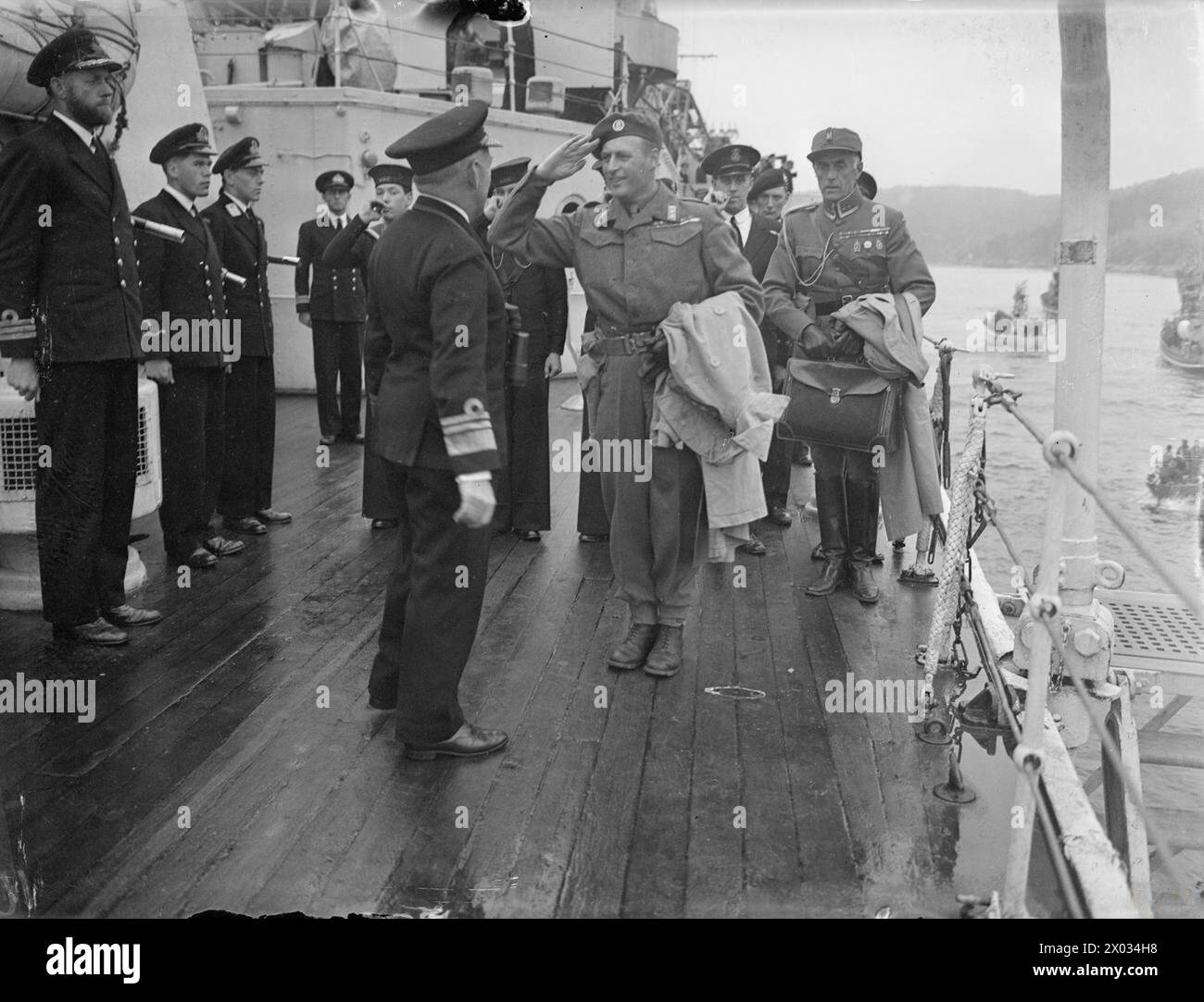 NORWEGEN HEISST KÖNIG HAAKON ZU HAUSE WILLKOMMEN. AM 6. UND 7. JUNI 1945 AN BORD DES BRITISCHEN KREUZERS HMS NORFOLK UND AN LAND, ALS HM KING HAAKON VON NORWEGEN UND DIE KÖNIGLICHEN KINDER NACH OSLO ZURÜCKKEHRTEN. - Kronprinz Olav, der die NORFOLK von einem Start aus bestieg, als der Kreuzer sich Oslo näherte, und Vizeadmiral McGrigor bei seiner Ankunft an Bord begrüßte Stockfoto