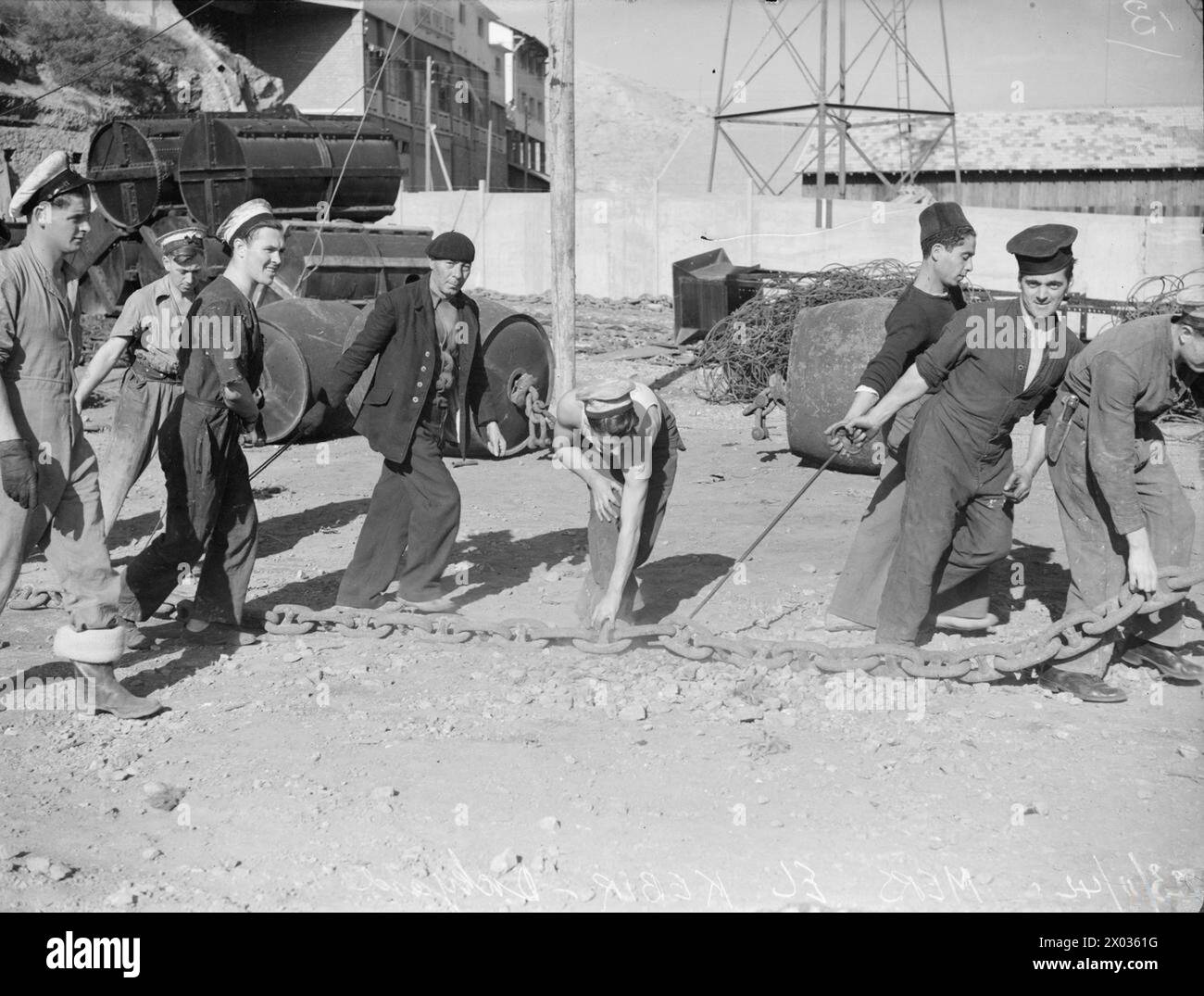 BRITISCHE SEELEUTE UND FRANZÖSISCHE HAFENARBEITER ARBEITEN BEI ORAN ZUSAMMEN. 22./23. NOVEMBER 1942, ORAN UND MERS EL KEBIR. - Britische Marinekräfte und französische Werftarbeiter arbeiten nach dem Waffenstillstand in Mers-el-Kebir nordwestlich von Oran zusammen Stockfoto