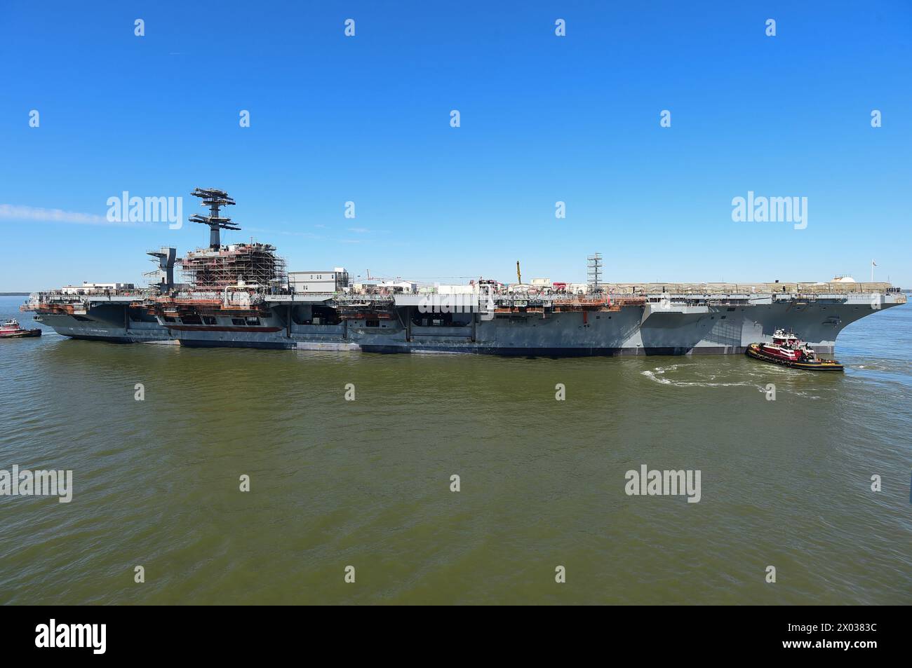 240408-N-KP843-1157 NEWPORT NEWS, VIRGINIA (8. April 2024) - der Flugzeugträger der Nimitz-Klasse USS John C. Stennis (CVN 74) wird auf einen Anlegeplatz verlegt Stockfoto