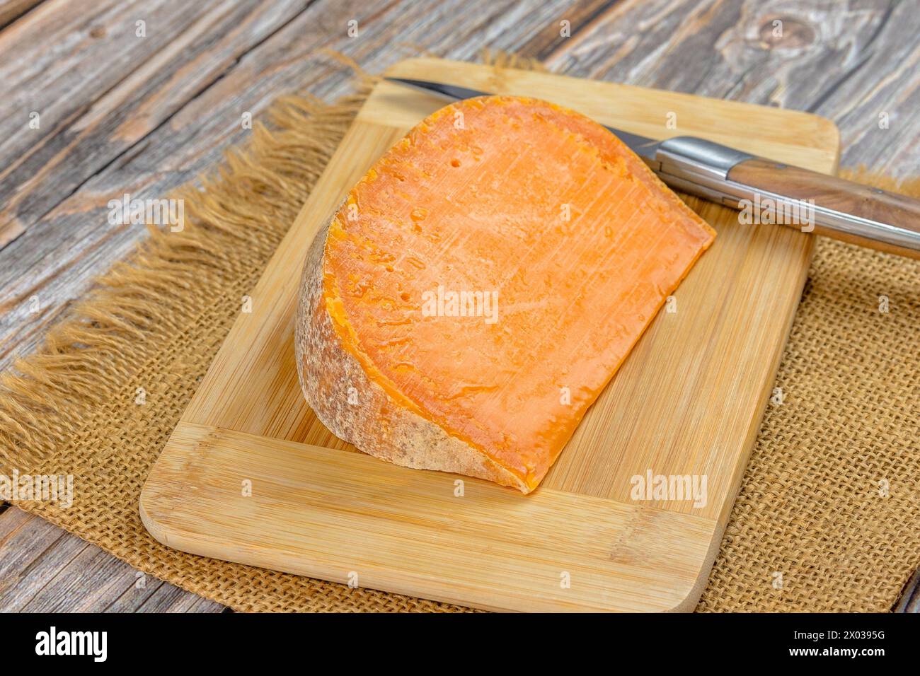 Französischer Käse: Extra alte Mimolette, Nahaufnahme, auf einem Schneidebrett Stockfoto