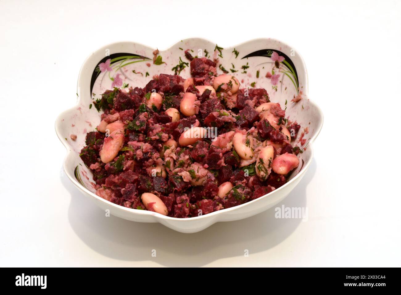 Ein Salat aus gekochtem Gemüse, Rüben, Karotten, Kartoffeln, Bohnen und gekochtem Thunfisch liegt auf einem tiefen Teller, Blick von oben. Stockfoto