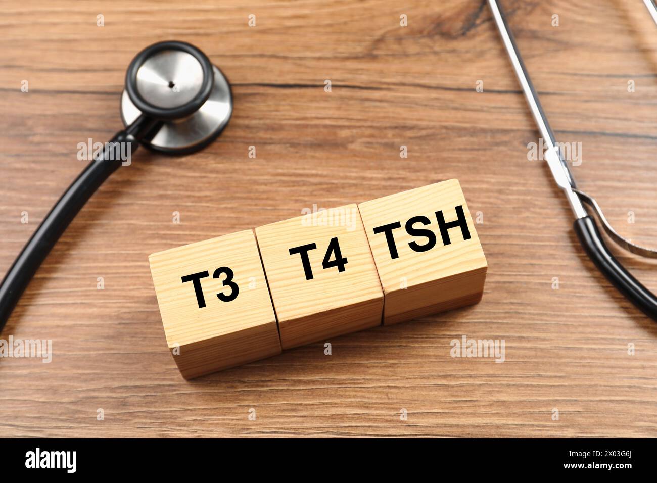 Endokrinologie. Stethoskop und Würfel mit Schilddrüsenhormonen auf Holztisch Stockfoto