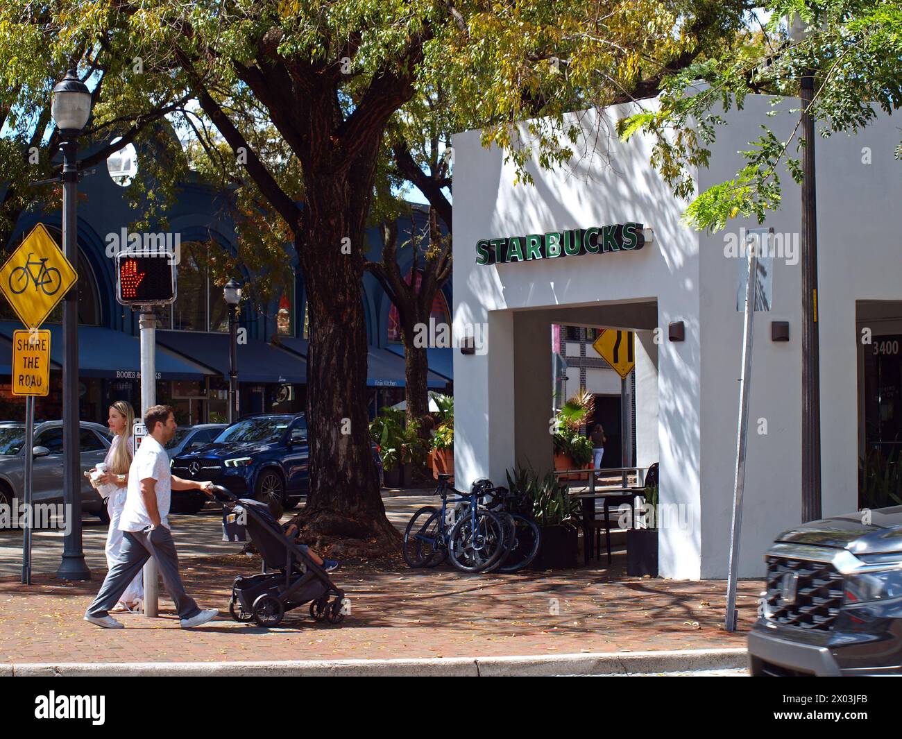 Miami, Florida, Vereinigte Staaten - 6. April 2024: Leute gehen an einem Starbuck Cafe in Coconut Grove vorbei. Stockfoto