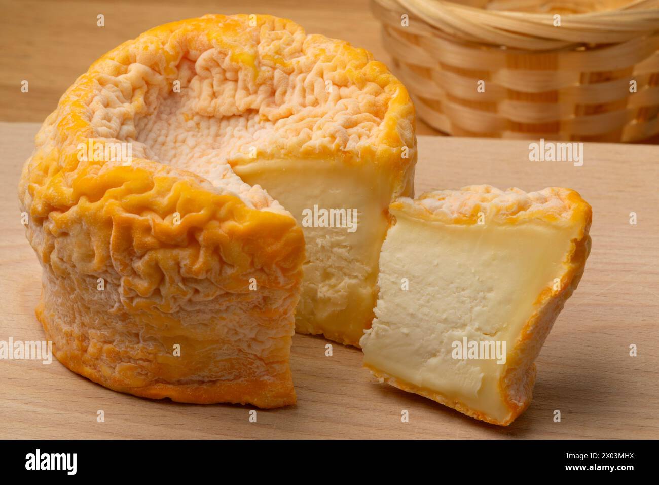Französischer Langres-Käse, verfeinert mit Champagner und einem Stück auf einem Schneidebrett aus nächster Nähe Stockfoto