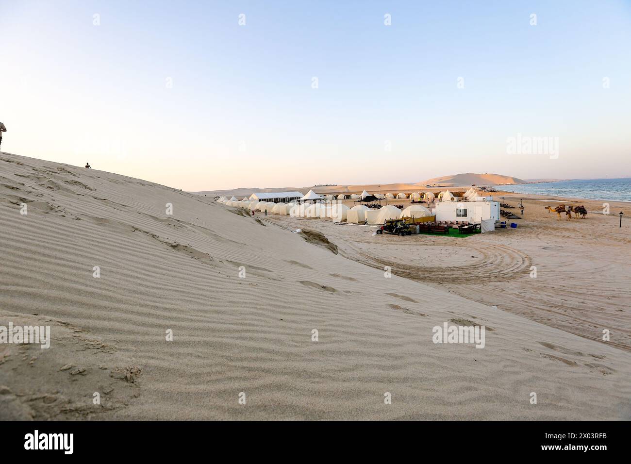 Zelte im QIA Wüstencamp am Binnenmeer im Persischen Golf bei Sonnenuntergang. Naher Osten, Arabische Halbinsel. Das Binnenmeer ist ein wichtiges Touristenziel, Katar Stockfoto