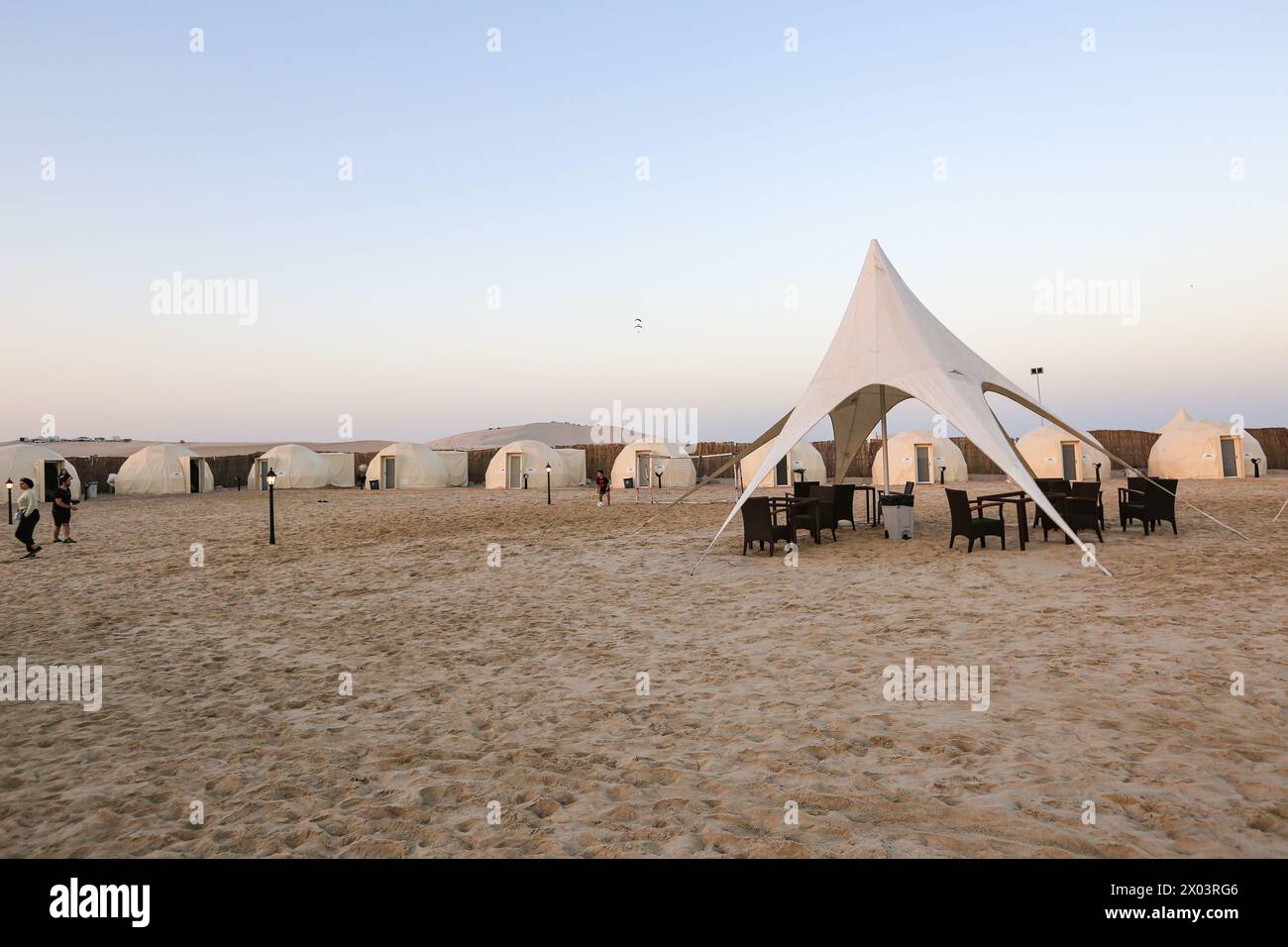 Zelte im QIA Wüstencamp am Binnenmeer im Persischen Golf bei Sonnenuntergang. Naher Osten, Arabische Halbinsel. Das Binnenmeer ist ein wichtiges Touristenziel. Stockfoto