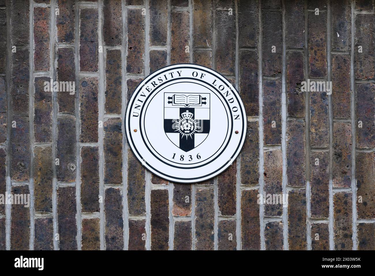 London, Großbritannien - 24. März 2024; Emblem der University of London an vertikaler Ziegelwand Stockfoto