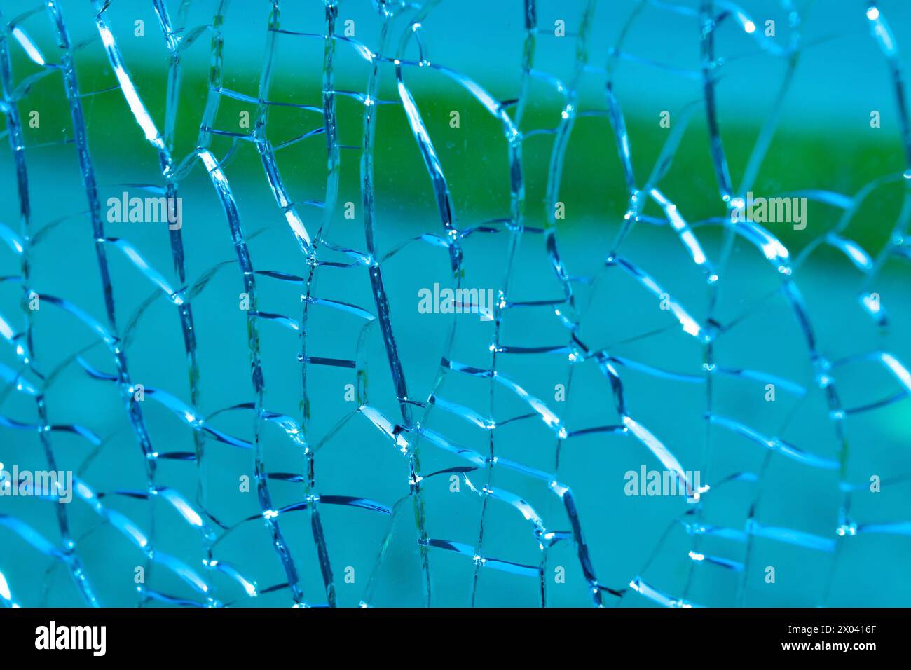 Risse auf blauem Glas, Nahaufnahme. Hintergründe und Texturen. Glasbruch, Zerstörung. Stockfoto