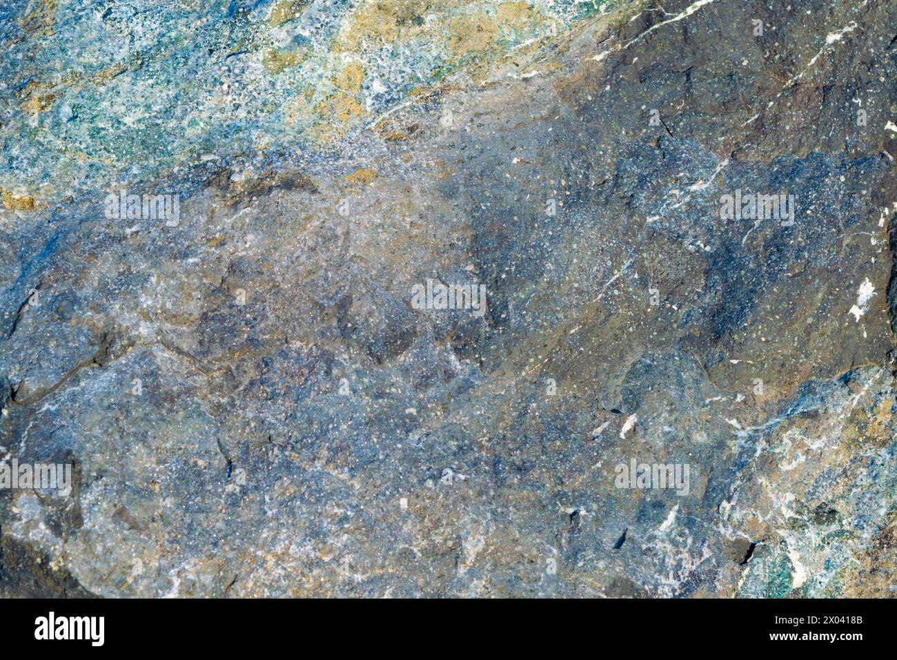 Glänzende, strukturierte Steinoberfläche, Nahaufnahme. Hintergründe und Texturen. Der Stein sieht aus wie der Weltraum. Stockfoto