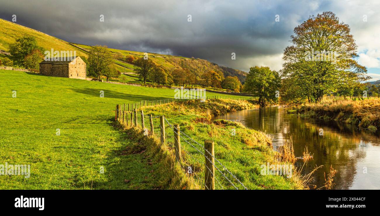 Felder und Steinscheune entlang des River Wharfe bei Kettlewell, Wharfedale, Yorkshire Dales, England. Stockfoto