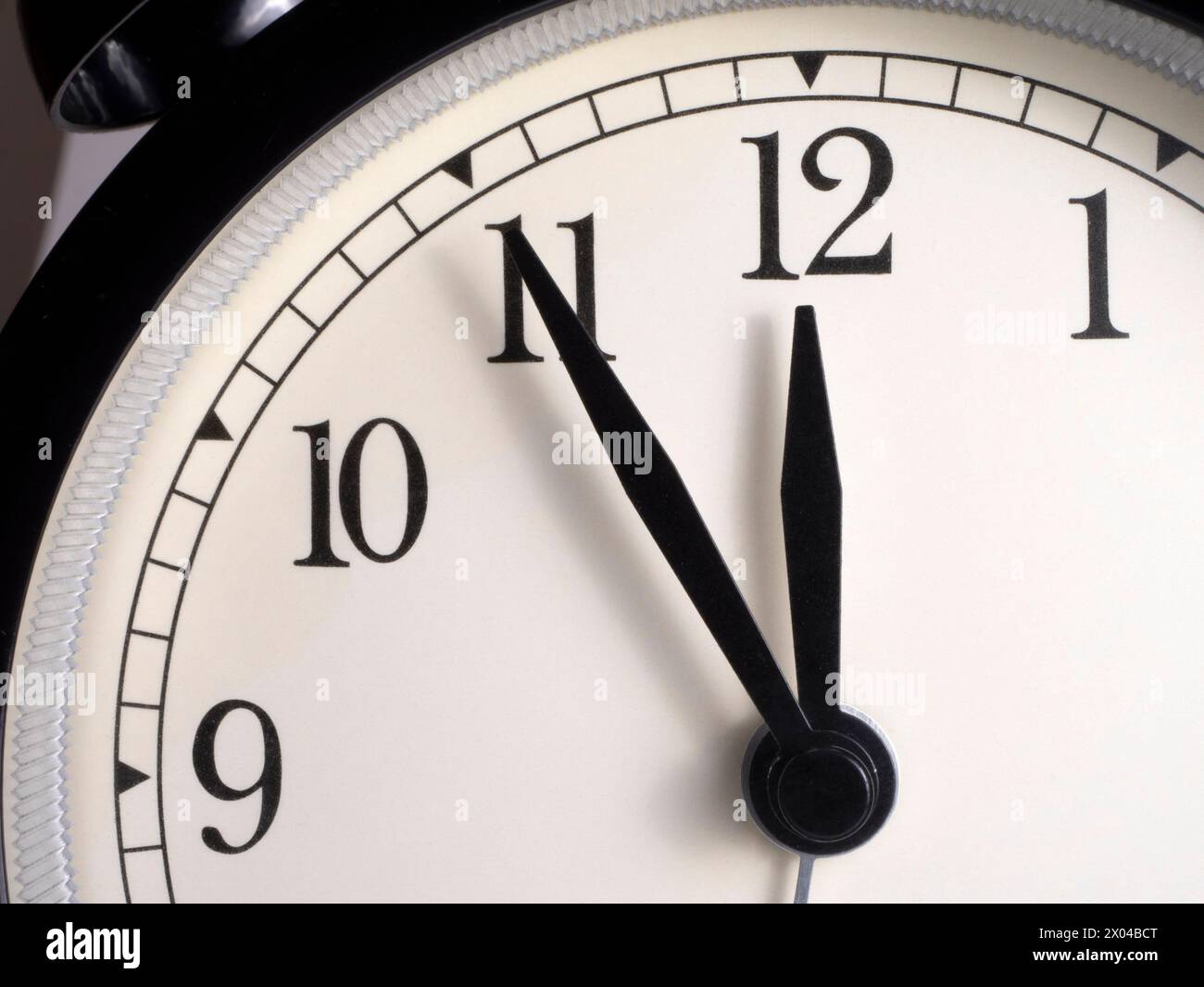 Das Zifferblatt einer Uhr, deren Zeiger die Zeit bei fünf bis zwölf Minuten anzeigen. Nahaufnahme. Stockfoto