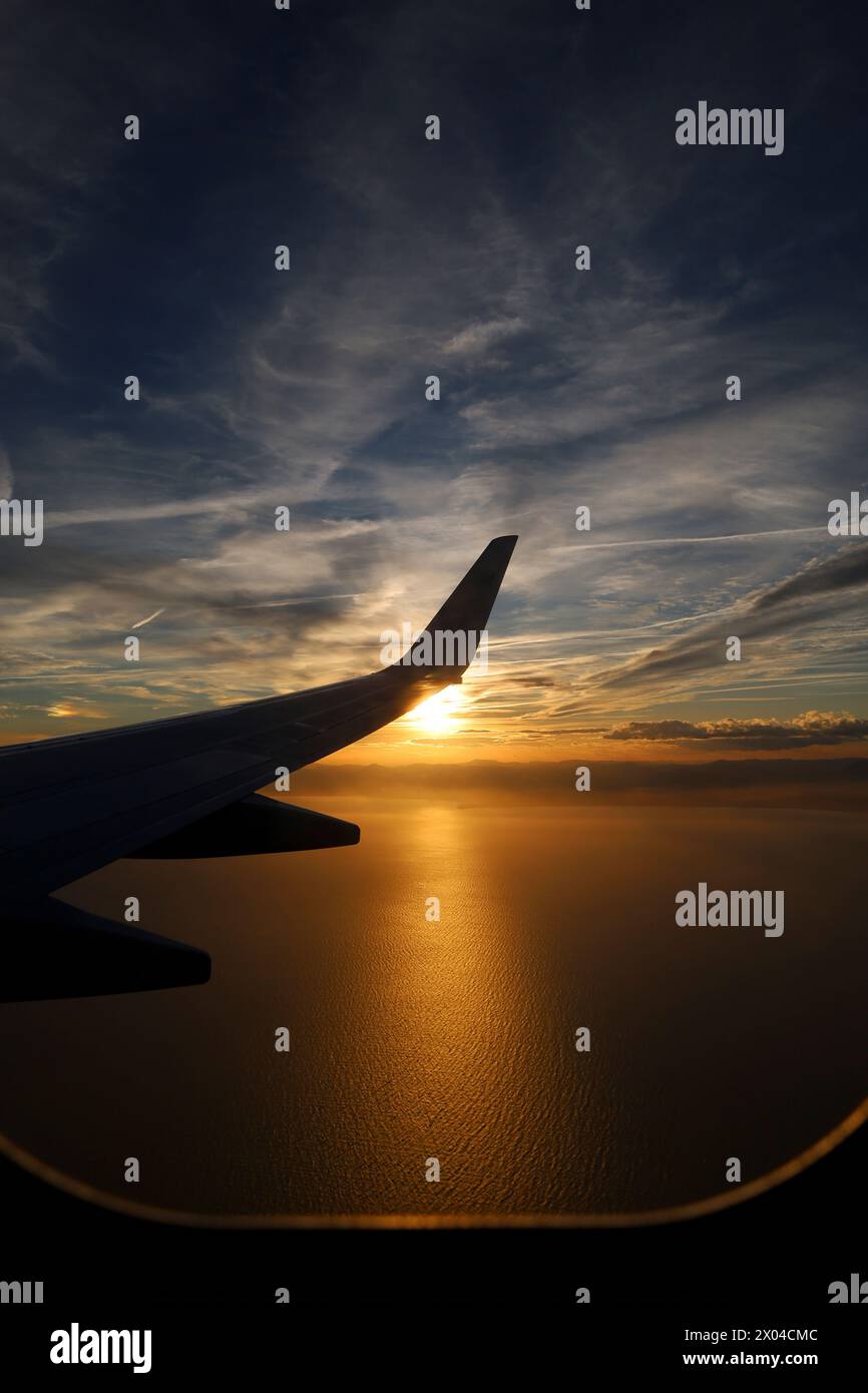 Flugzeug fliegt bei Sonnenuntergang über die Mittelmeerküste von Alicante, Spanien Stockfoto