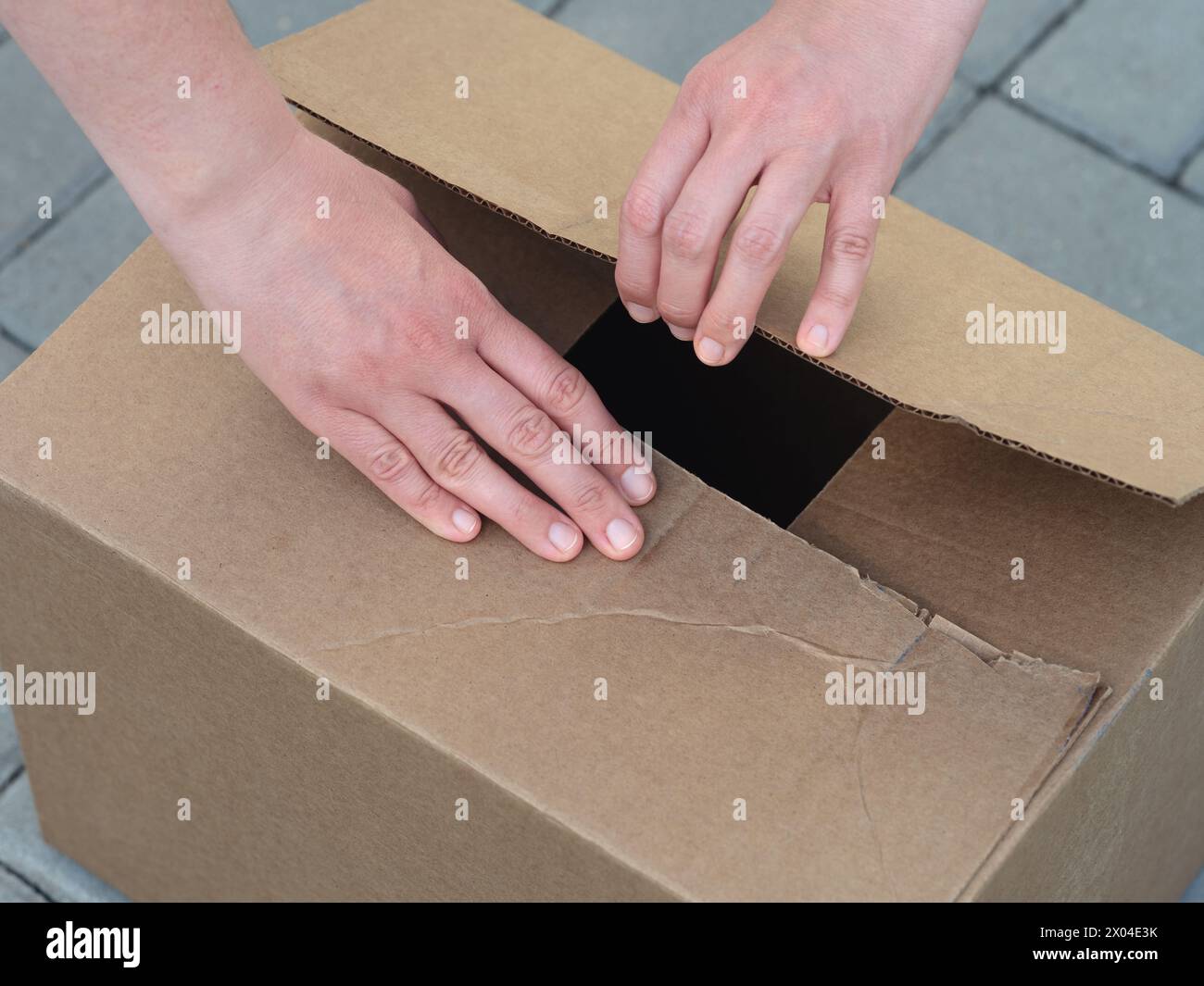 Eine Frau, die einen Karton öffnet. Nahaufnahme. Stockfoto