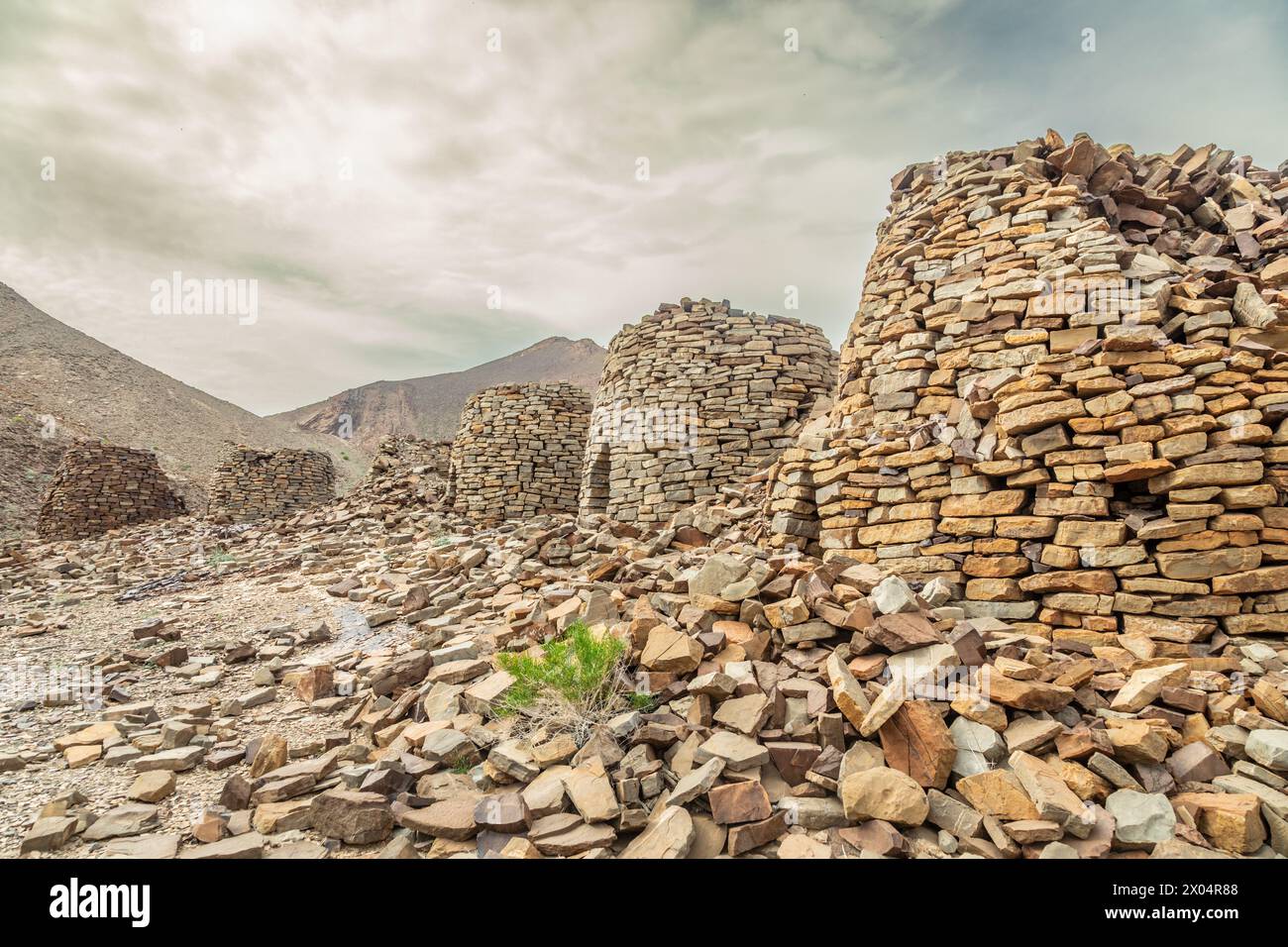 Alte Steingräber mit Berg Jebel Misht im Hintergrund, archäologische Stätte in der Nähe von al-Ayn, Sultanat Oman Stockfoto