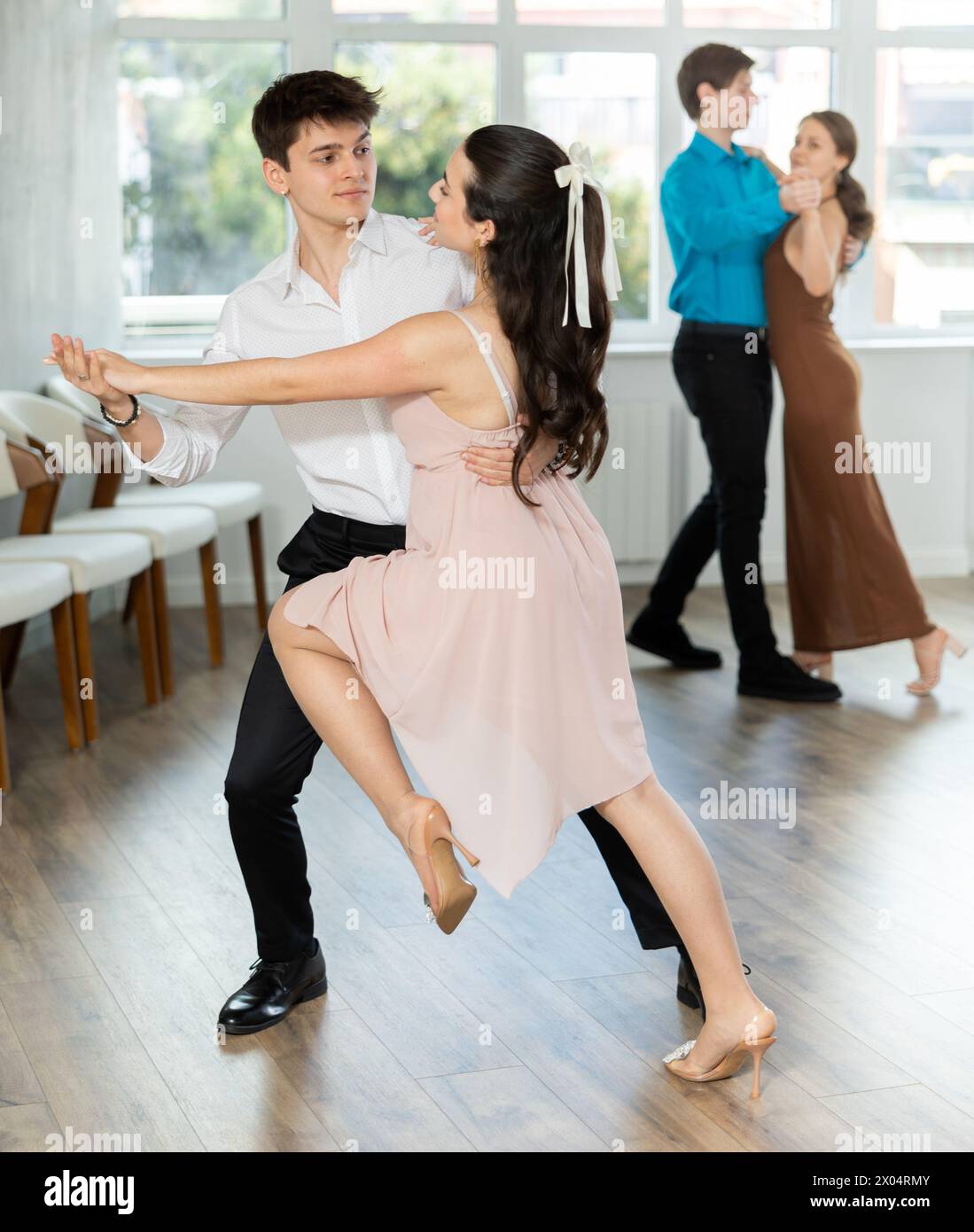 Der hispanische Typ probt Tango mit einer jungen Partnerin Stockfoto