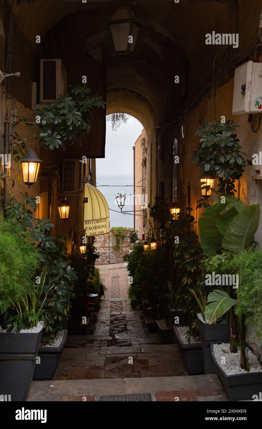 Eine Straße in Taormina führt zu einem Blick auf das Ionische Meer Stockfoto