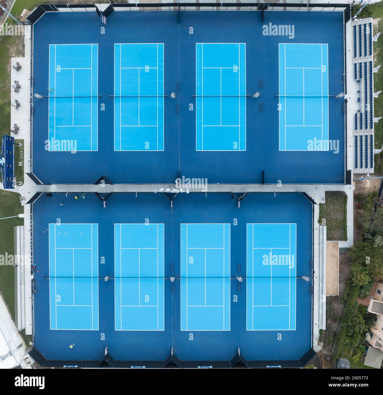 Blick aus der Vogelperspektive auf acht Tennisplätze, die mit blauem Kunstrasen bedeckt sind Stockfoto