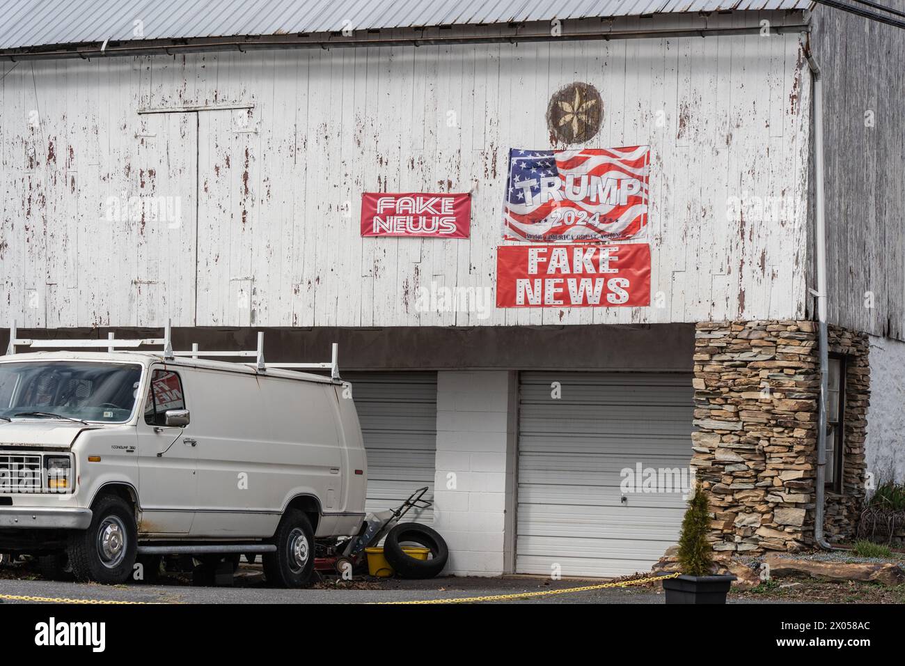 Lancaster County, Pennsylvania – 7. März 2024: Trumps Wahlzeichen 2024 und Fake News-Zeichen auf der Seite einer Scheune mit Hexenschild im ländlichen Lancaster Cou Stockfoto