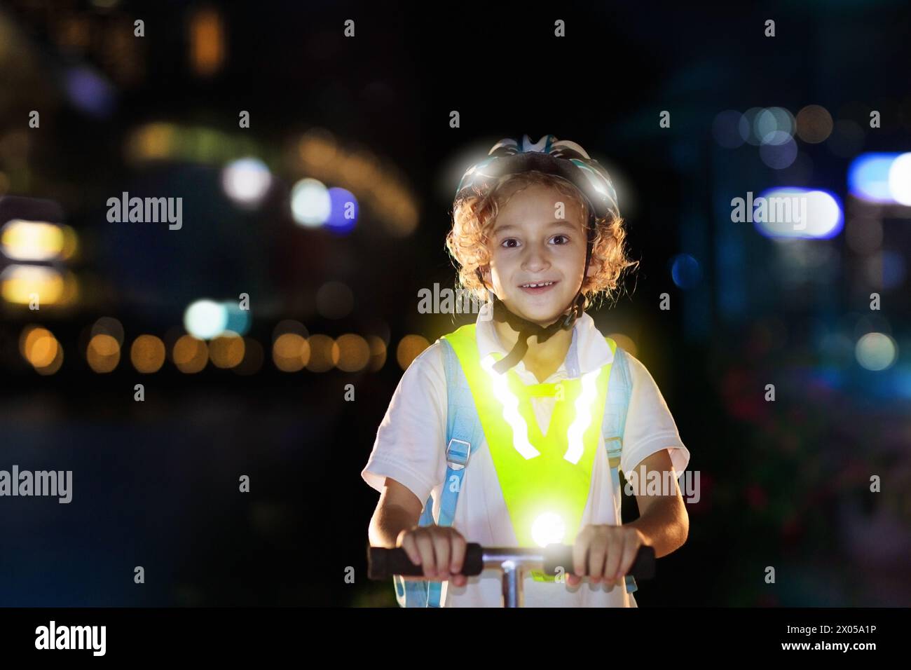 Kind in reflektierender Weste im Dunkeln. Sicherheit auf dunklen Straßen für Schulkinder. Sicherer Weg nach Hause in der Nacht oder am Abend. Fluoreszierende Streifen Stockfoto